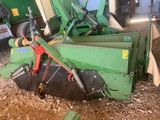 une machine verte qui est à l'arrêt dans la poussière