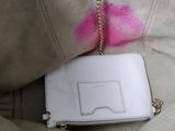 a white purse with pink lipstick on it sitting on a couch