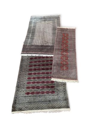 trois tapis de couleurs et de motifs différents posés sur un fond blanc