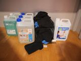 three bottles of cleaner and a black bag on the floor