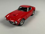a red toy car that is sitting on a white surface