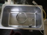a metal sink with a strainer and a strainer in it