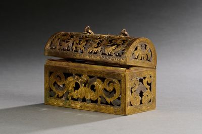 une boîte en or ornée de sculptures, posée sur une table