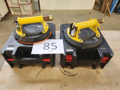 deux crics hydrauliques portatifs jaunes et noirs posés sur une table en bois
