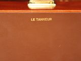 a brown suitcase sitting on top of a wooden table