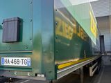 un gros camion vert garé sur un parking