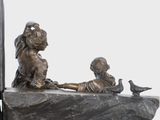 a statue of a boy and a girl sitting on a ledge