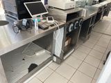 une image d'une cuisine commerciale avec des plans de travail en acier inoxydable