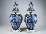 pair of blue and white vases with figures on them
