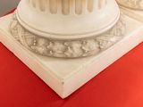 two white marble columns on a red table