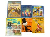several children ' s books are lined up on a white surface
