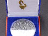 a close up of a silver coin in a blue box on a table