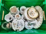 a green container filled with tea cups and saucers