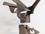 a metal sculpture of a bird on a white wall