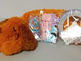 a teddy bear that is laying down next to a bag of candy