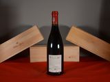 a bottle of wine sitting on a table next to two wooden boxes