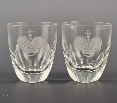 lot de deux verres à shot en verre gravé posés sur un support noir