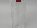 a clear glass vase with a red label on it