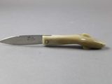 a close up of a knife on a table with a white background