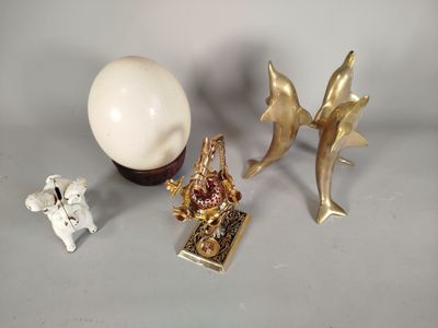 trois figurines posées sur une table, à côté d'un œuf blanc