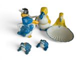 three figurines that are sitting on a white surface