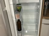 un réfrigérateur ouvert dans lequel se trouve une bouteille de bière