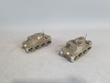 two toy tanks sitting side by side on a white surface