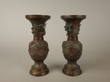two bronze vases sitting next to each other on a table