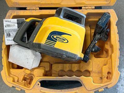 une mallette jaune contenant des outils, posée par terre
