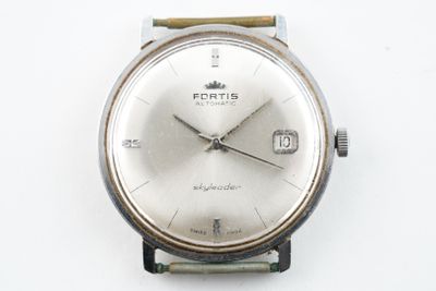 une montre posée sur une surface blanche