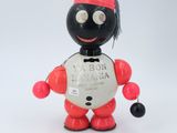 a red and black robot toy with a coin in its hand