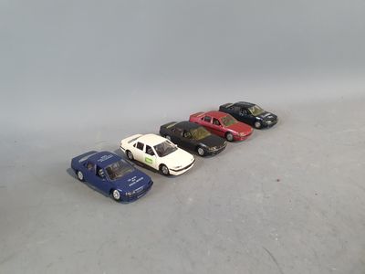 several toy cars are lined up in a row on a white surface