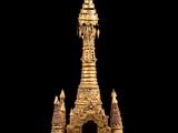 une statue dorée représentant une pagode sur fond noir