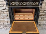 a black and gold painted side table with drawers