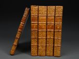 several old books are stacked on top of each other on a table