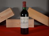 a bottle of wine sitting on a table next to two wooden boxes
