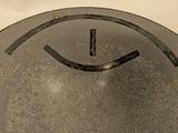 a clock with a smiley face on it sitting on a table