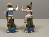 two figurines of a woman and a man on a pedestal