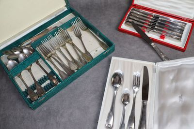une boîte contenant des couverts, posée sur une table à côté d'un couteau, d'une fourchette et d'une cuillère