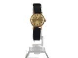 a close up of a watch on a stand on a white surface