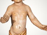 an antique statue of a little boy with a bow on his head