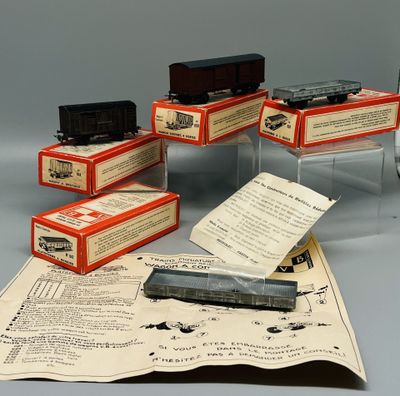 cinq petits wagons posés sur une feuille de papier