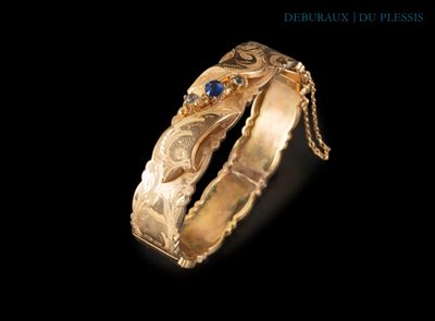 Gros plan sur une bague en or ornée d'une pierre bleue