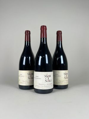trois bouteilles de vin sont alignées sur une table