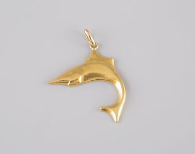 a gold dolphin pendant on a white background