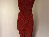 deux mannequins dans une pièce, dont l'un porte une robe rouge sur un pied de mannequin