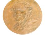 a gold medal with a picture of a man on it