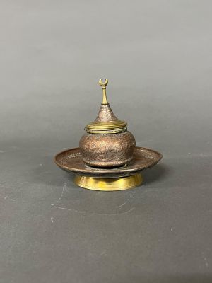 un brûleur d'encens ancien en laiton, surmonté d'un dôme