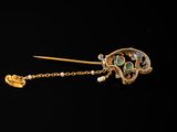 an image of a gold and emerald broochle with a chain