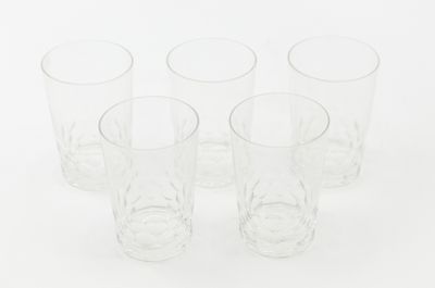 six clear glasses are lined up in a row on a white surface